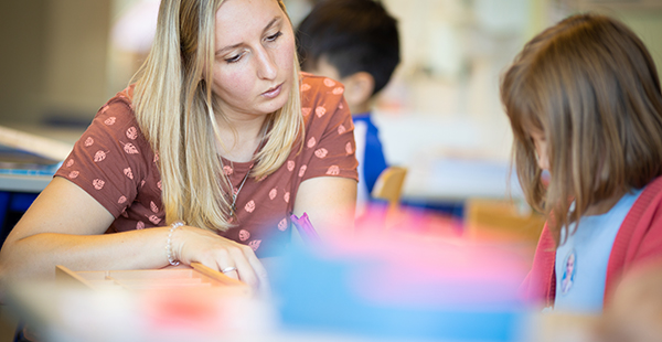 Lehrerin hilft Schüler in der Schule Inklusion